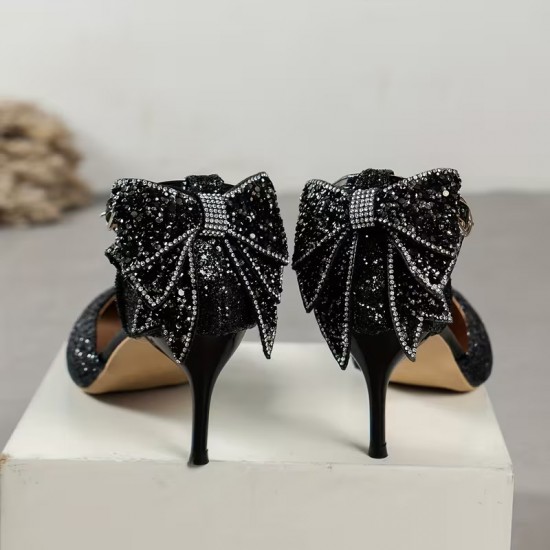 Elegant black glitter stiletto heel with pointed toe, ankle strap, and decorative bow for women