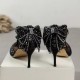 Elegant black glitter stiletto heel with pointed toe, ankle strap, and decorative bow for women