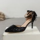 Elegant black glitter stiletto heel with pointed toe, ankle strap, and decorative bow for women